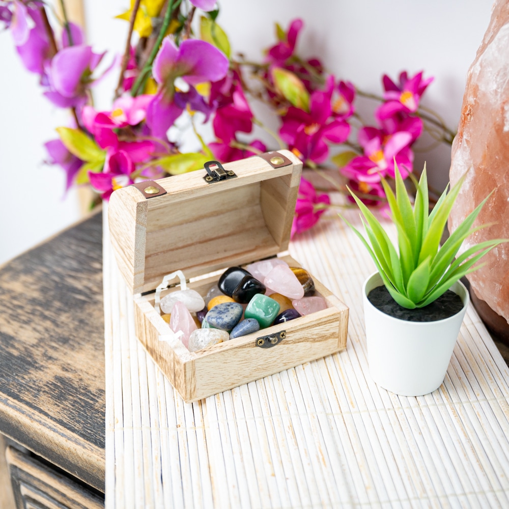wooden chest full of tumbled gemstones