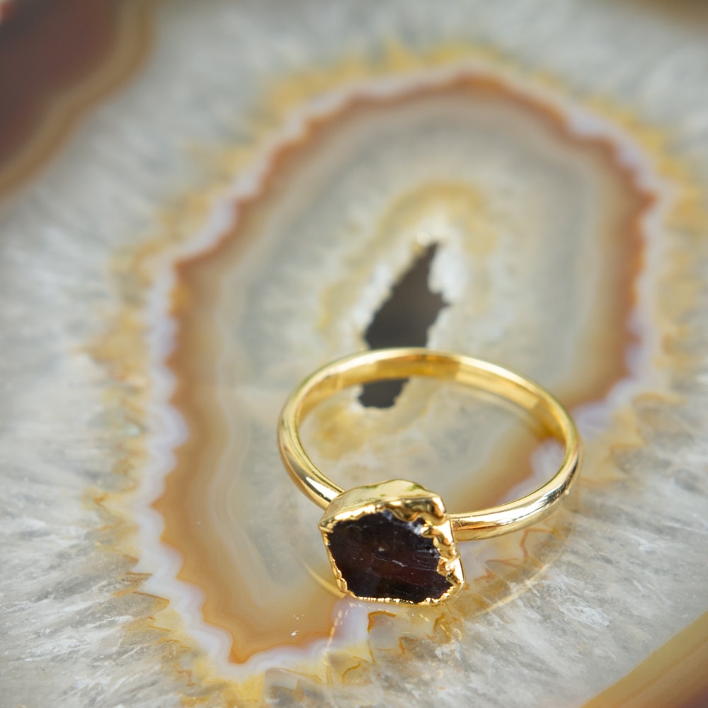 raw garnet ring on brown agate slice