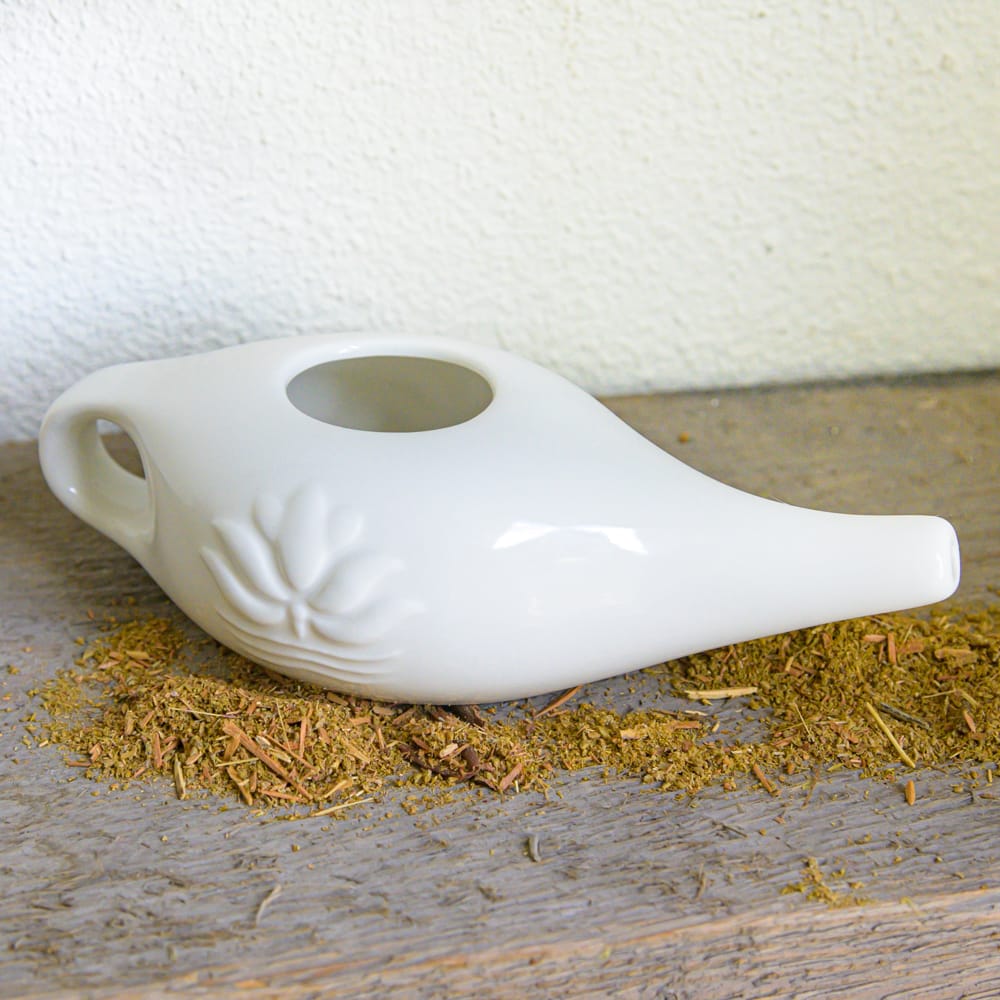 white ceramic neti pot with spices
