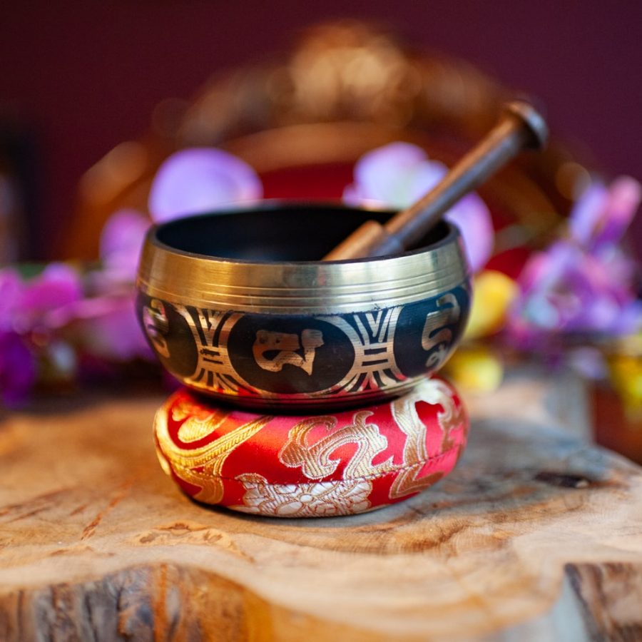 tibetan singing bowl on red chakra cushion