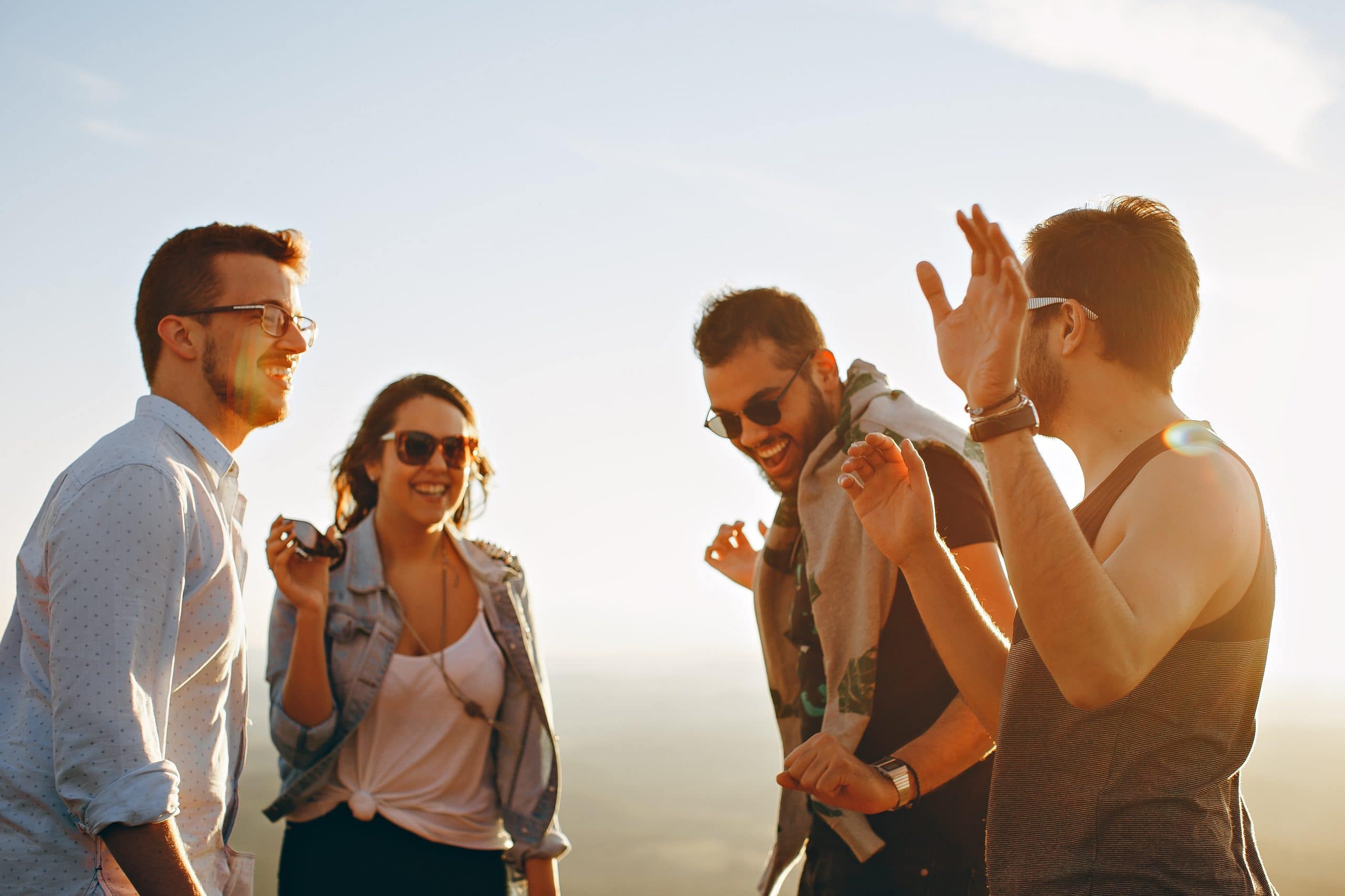 group of friends laughing outside in sun