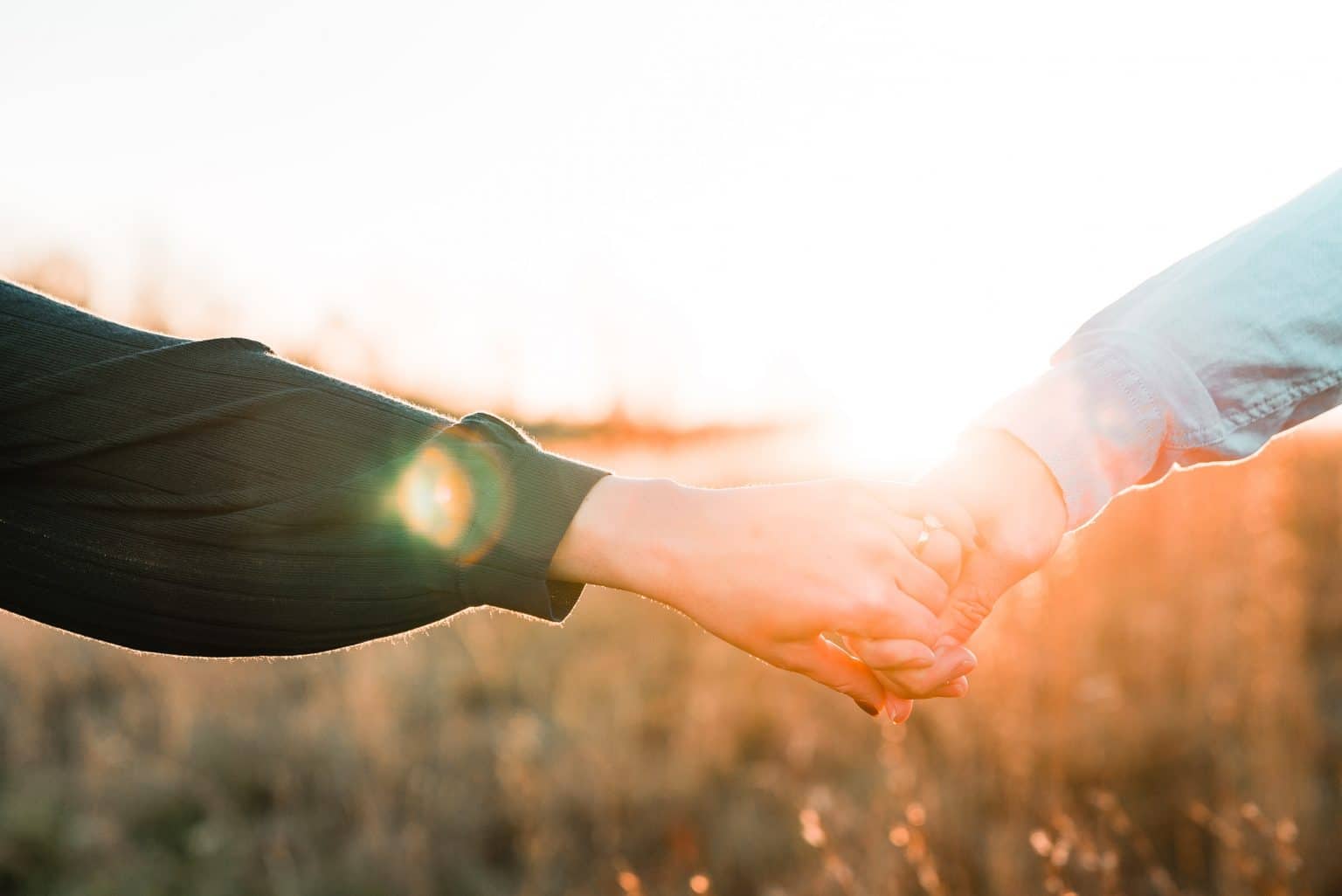 holding hands at sunset