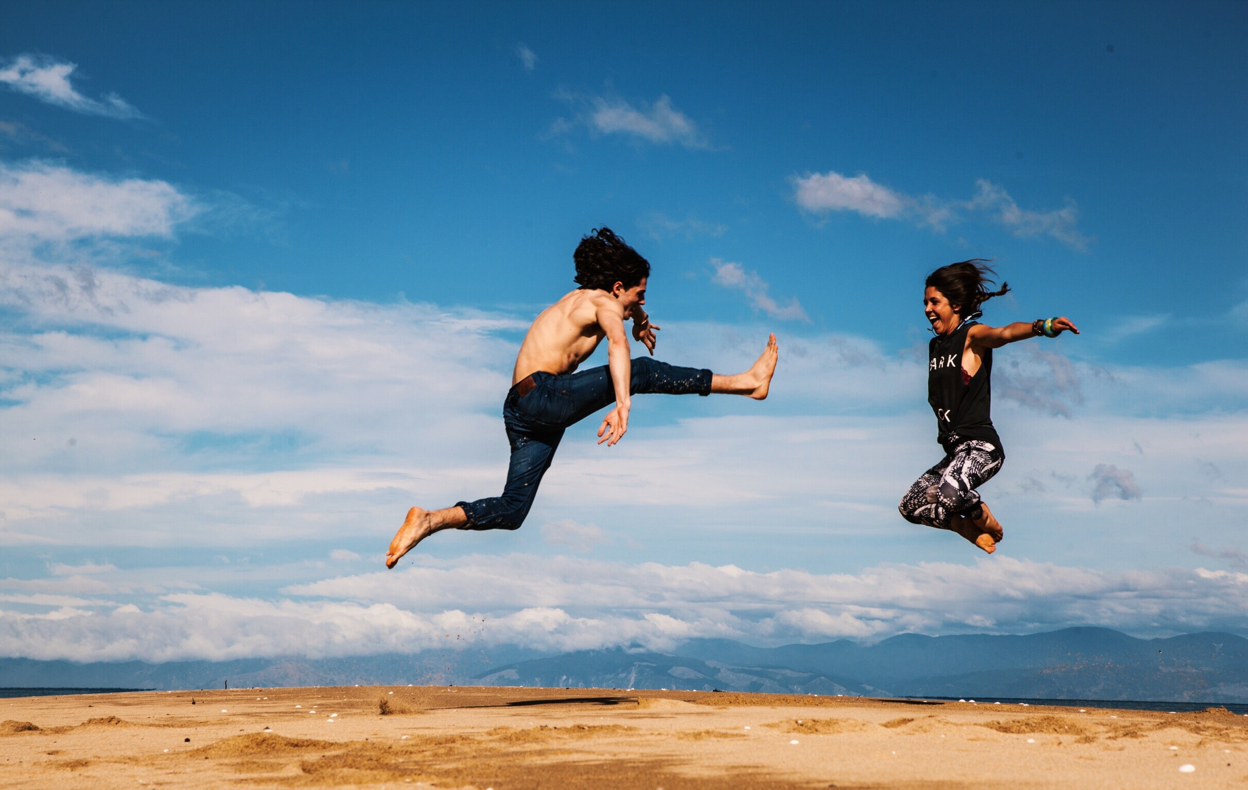 couple jumping sunny day