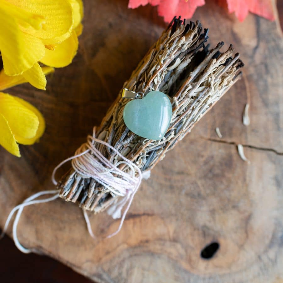 green aventurine heart on white sage smudge