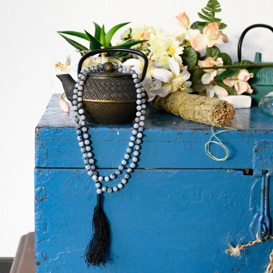 mala beads ona teapot with smudge stick