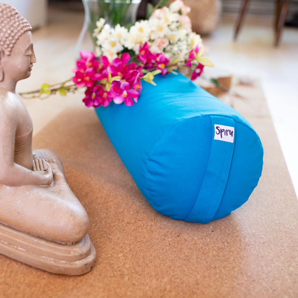 blue yoga bolster spiru on cork yoga mat Buddha statue