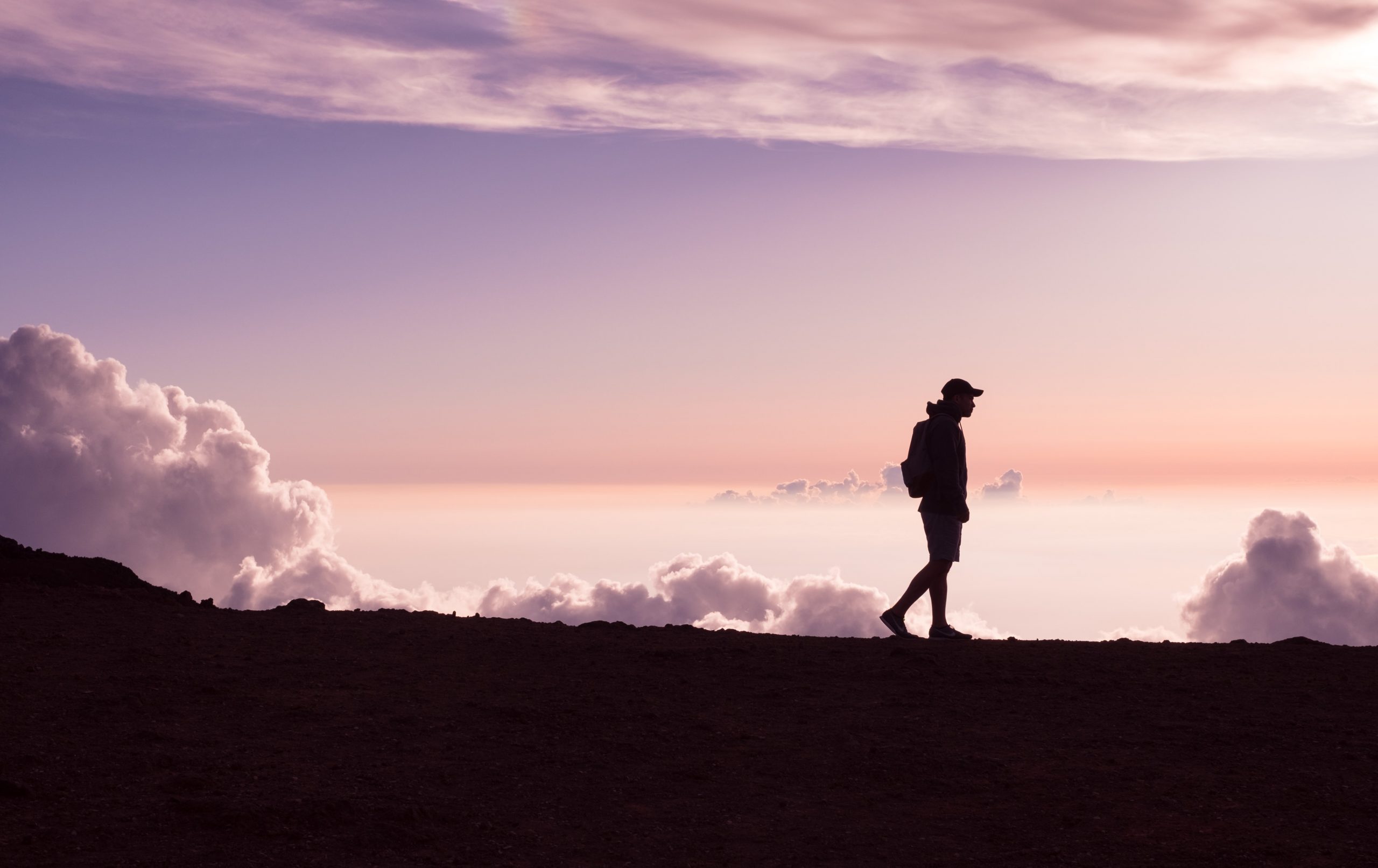 person walking silhouette pink sunset clouds