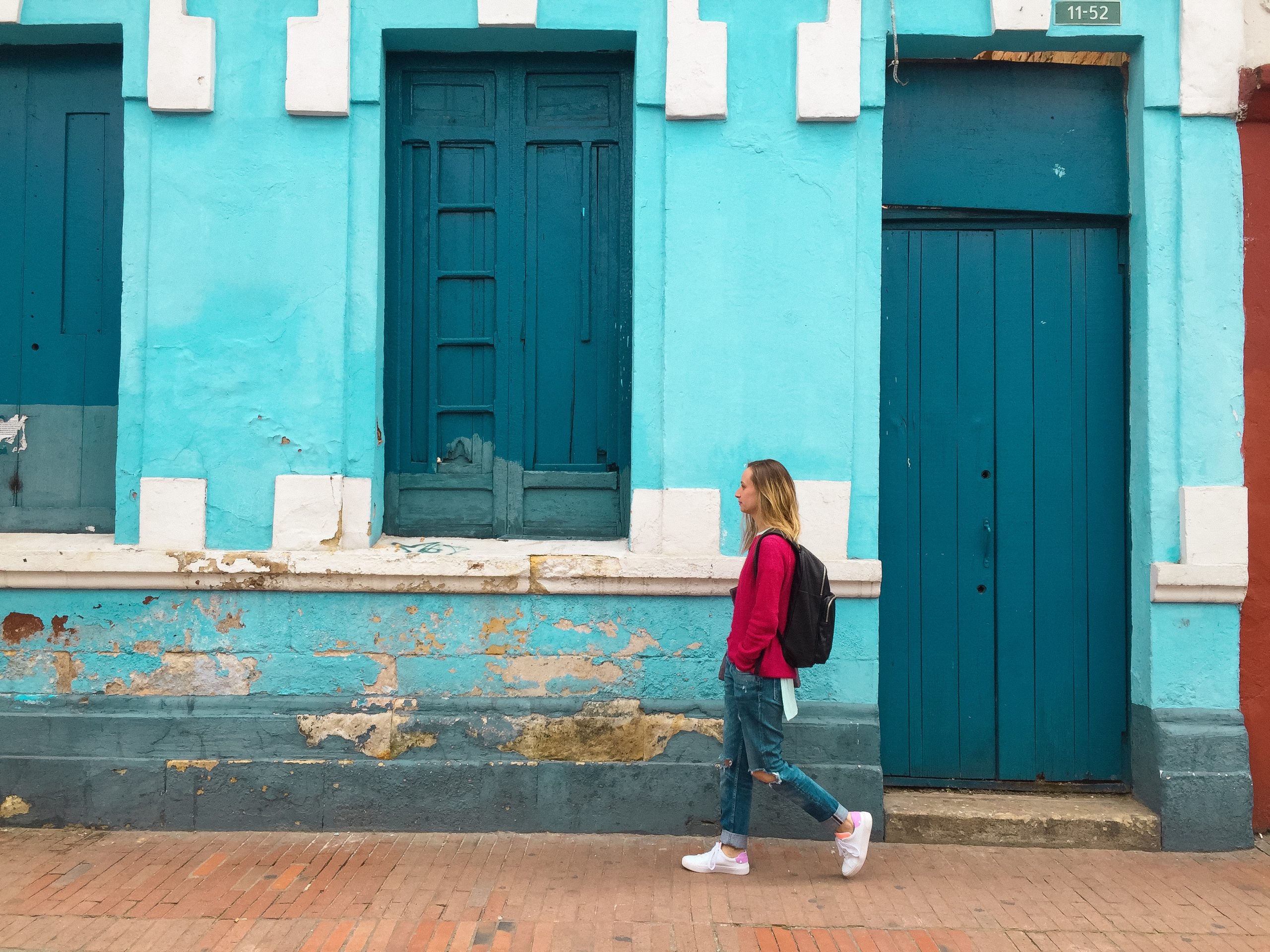woman walking blue building