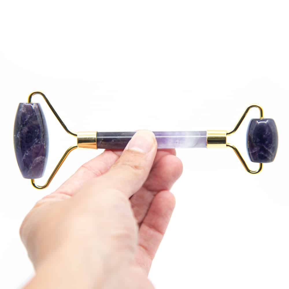 purple amethyst facial massage roller in hand