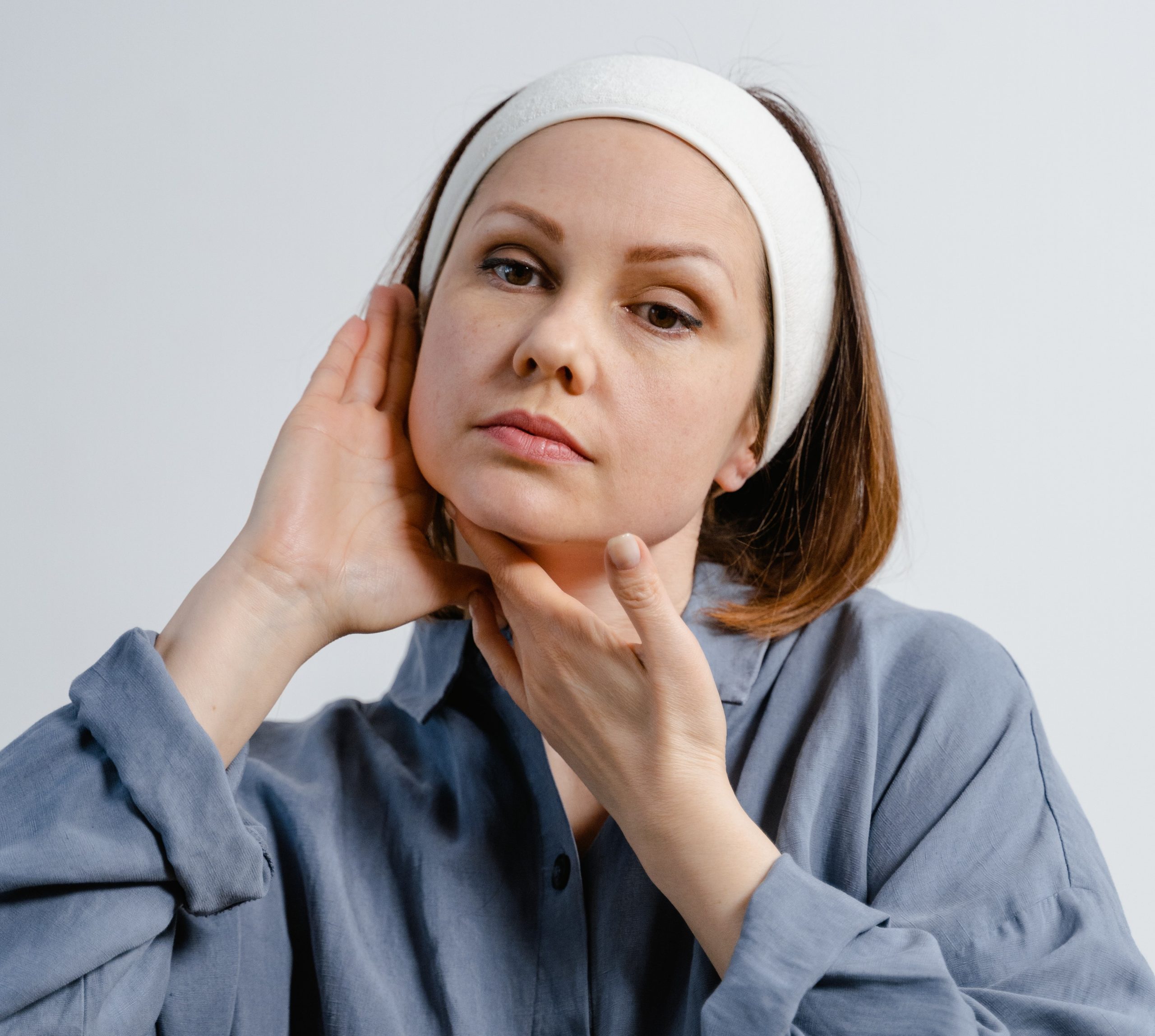 woman white headband facial yoga massage blue shirt
