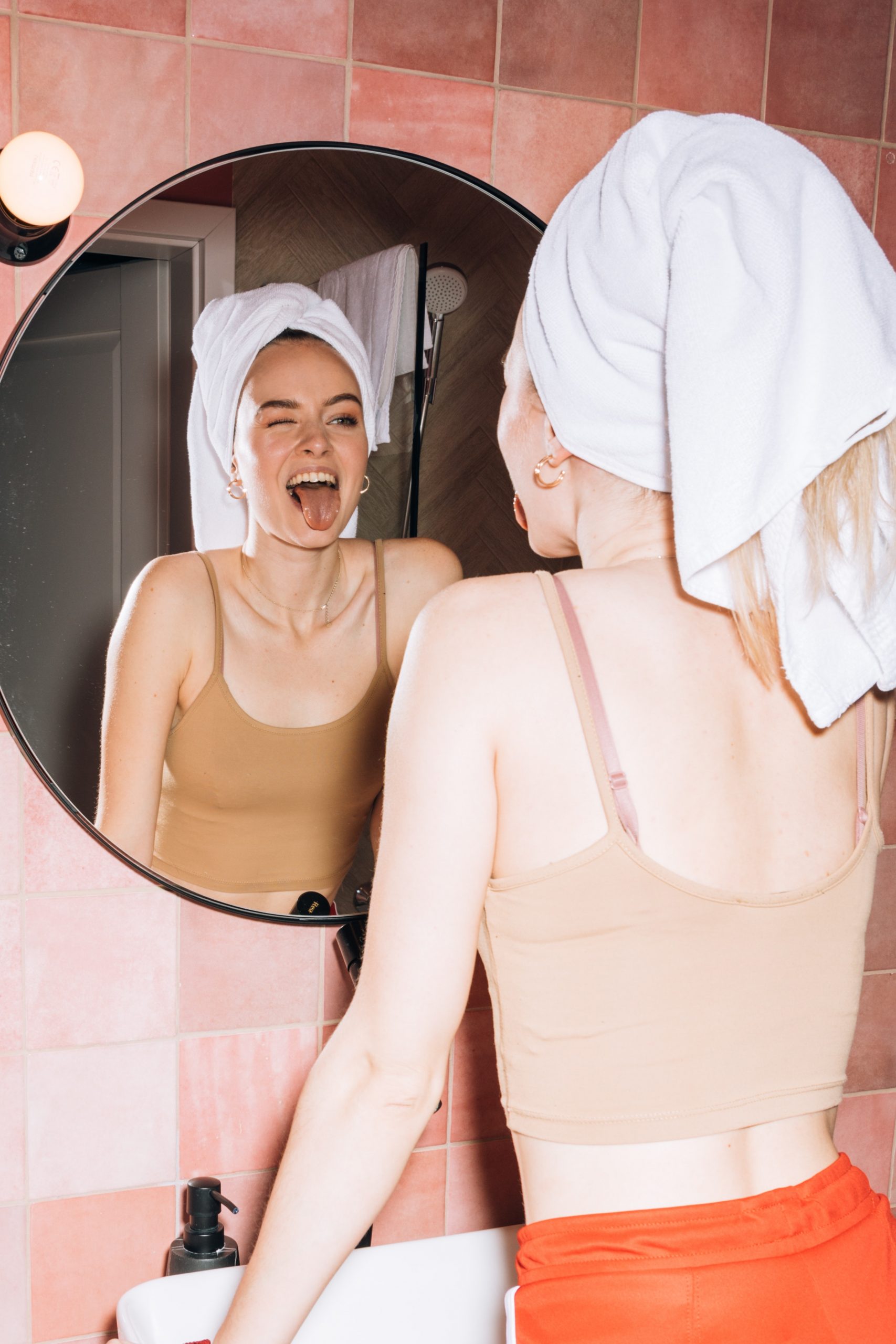 sticking tongue out bathroom mirror towel pink tiles