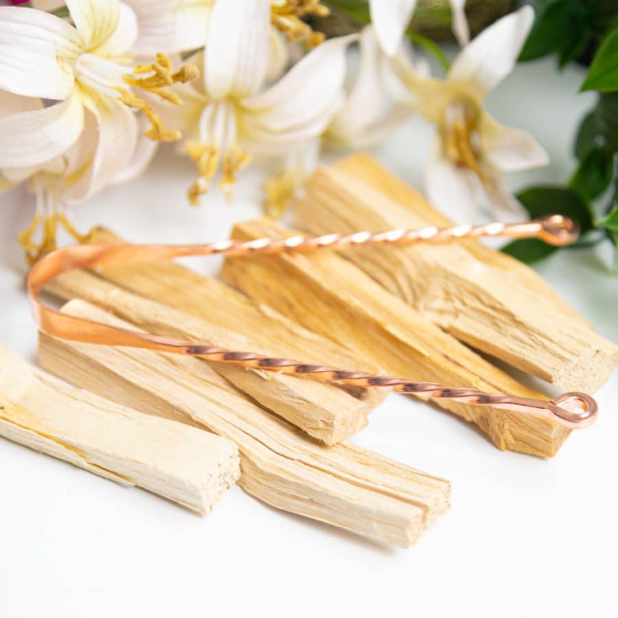 copper tongue scraper on palo santo