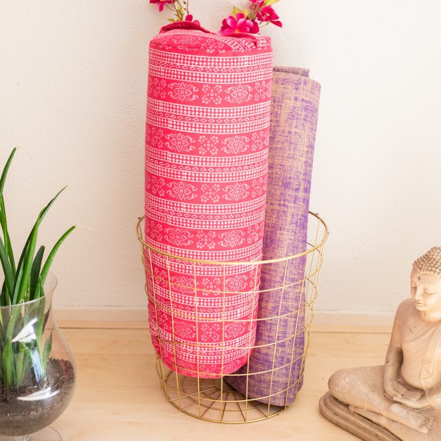 purple yoga mat and pink yoga bolster
