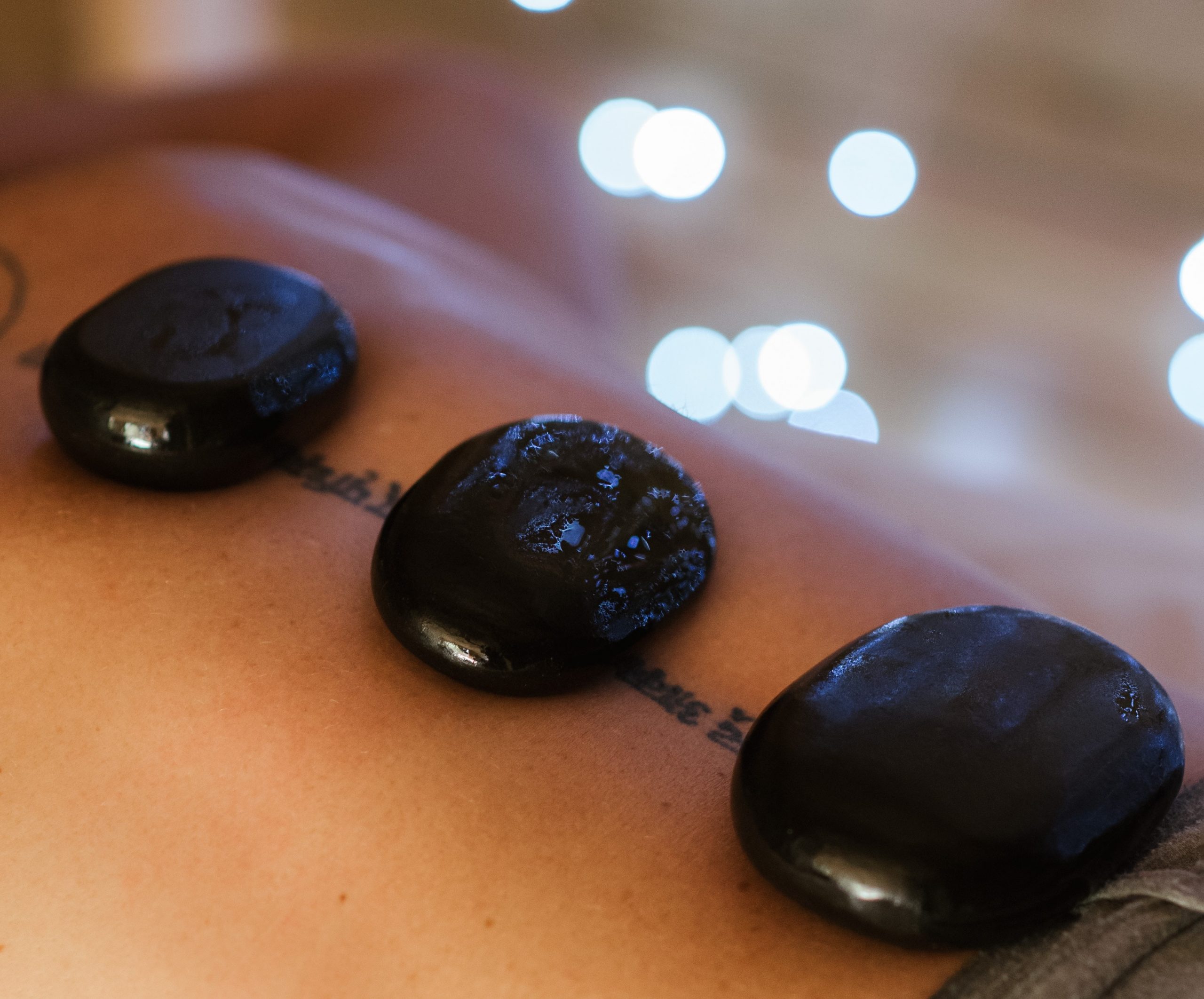 basalt massage stones on back sanskrit tattoo