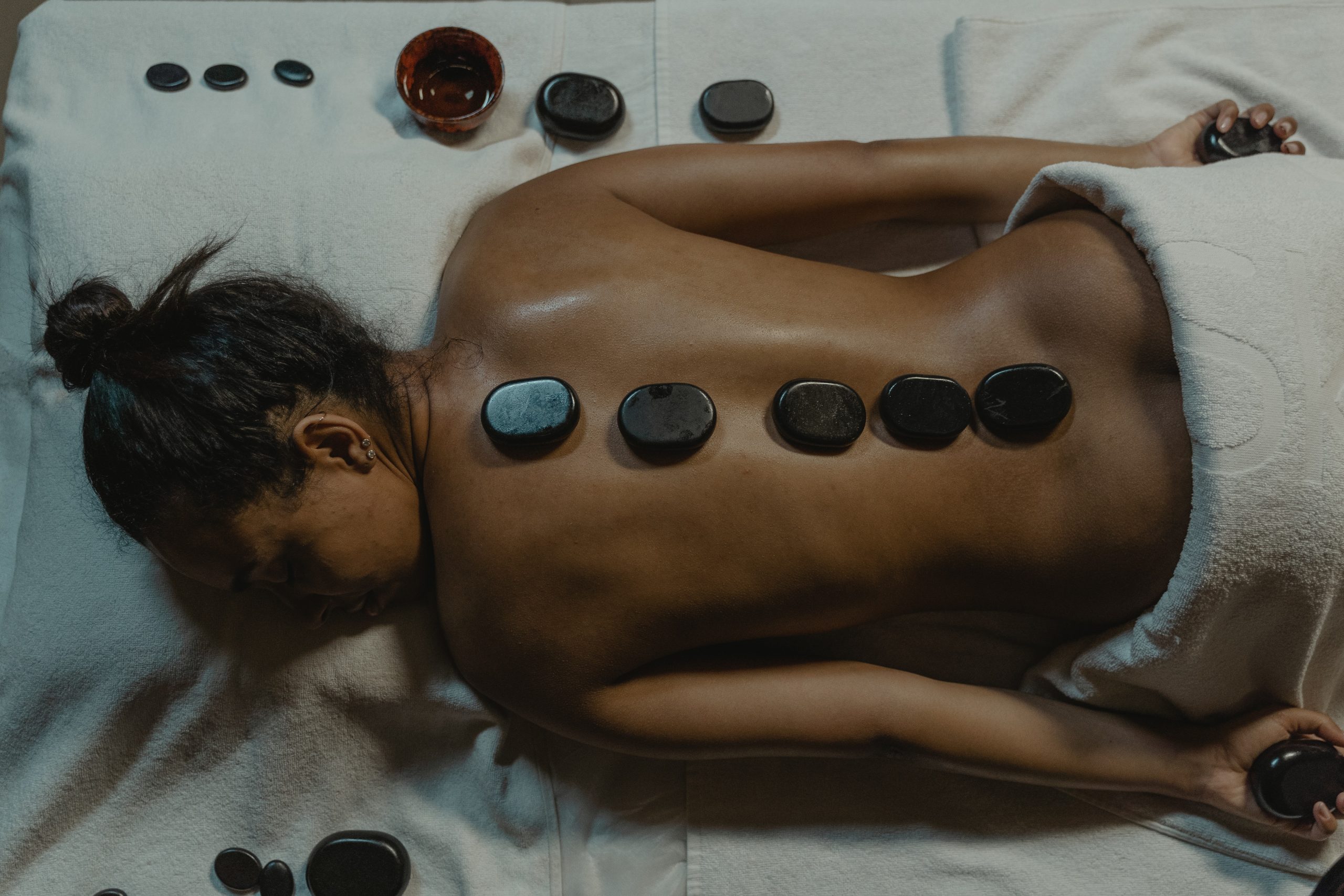 hot stone massage on white towel woman