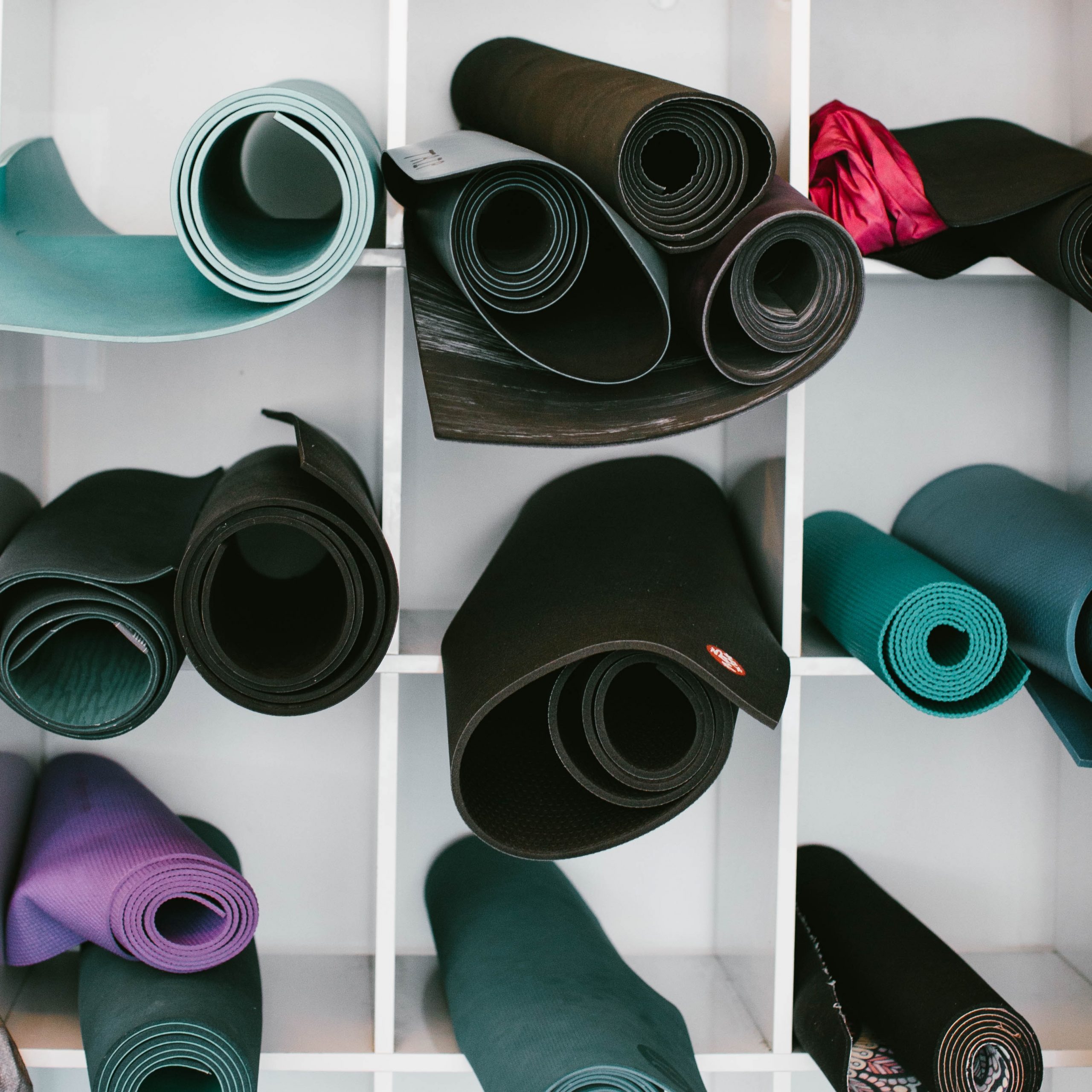 diverse yoga mats rolled up blue black purple turquoise manduka